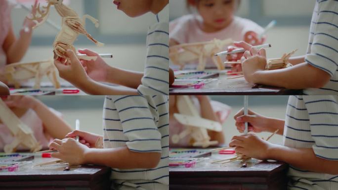 图为小女孩手上正在组装木制玩具上色