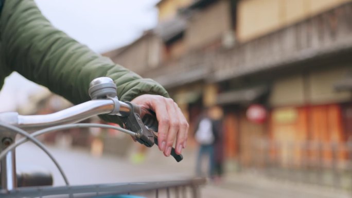 城市道路上积极骑行者的手、自行车及刹车把手，以保持健康。特写，按车把和骑自行车的人来控制或检查在日本