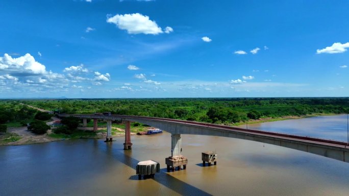 令人惊叹的无人机拍摄巴拉圭河和桥梁的视频，展示了晴朗蓝天下广阔的潘塔纳尔湿地。正在维修的桥梁增添了独