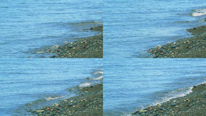 透过清澈的海浪，可以看见海石。《海边的鹅卵石》
