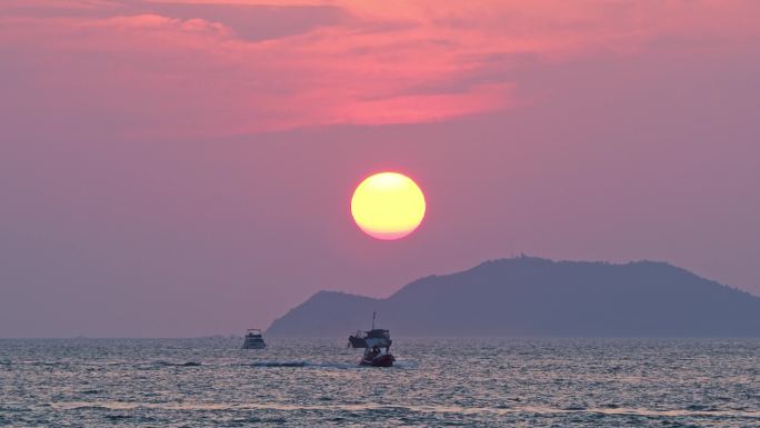 海南三亚橘红色夕阳晚霞行驶的巨型豪华游艇