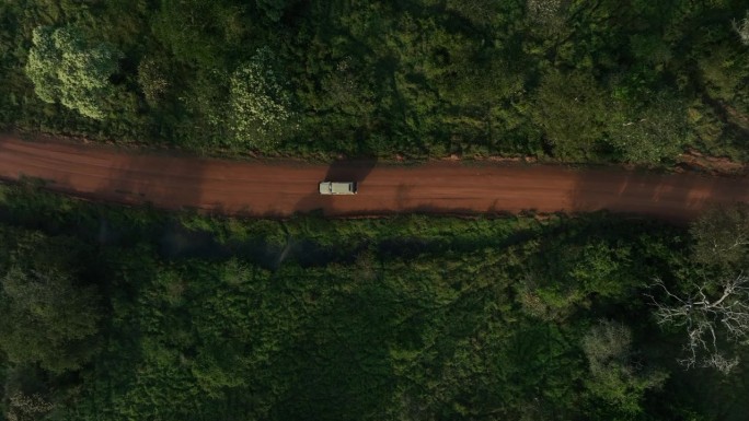 旅游卡车行驶在非洲乌干达国家公园的土路上。