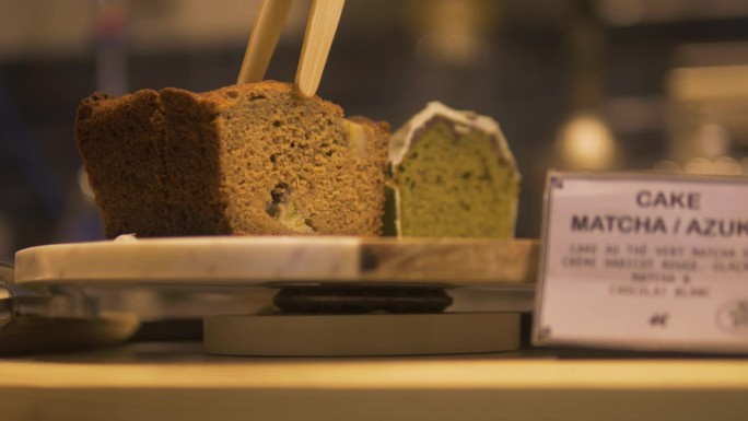 法国一家面包店里的法式蛋糕正在用一把木制的厨房钳子端给顾客