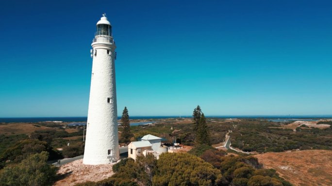 在一个阳光明媚的日子里，无人机在罗特内斯特岛的瓦杰马普灯塔附近飞行，展示了西澳大利亚州的风景