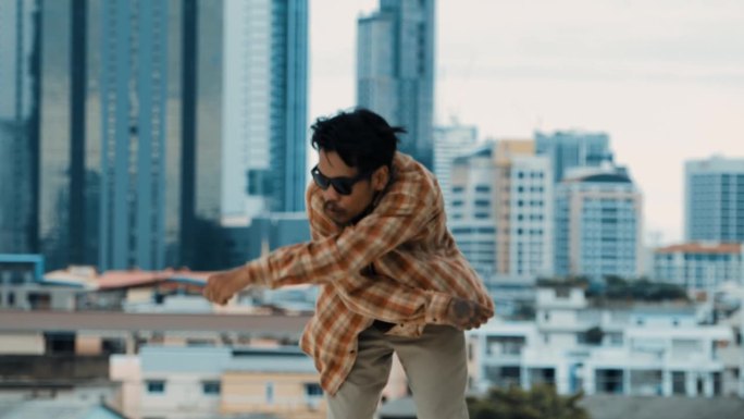 西班牙霹雳舞演员在屋顶与城市练习B-boy的脚步。嘻哈。
