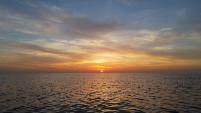大海上壮丽的日落。航拍的太阳从地平线落下。明亮的橙色和黄色日落在水面上