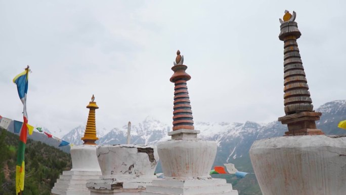 喜马拉雅山佛塔上随风飘扬的经幡。拉胡尔的沙舒尔修道院在恶劣天气下面对雪山。暑假在山里。