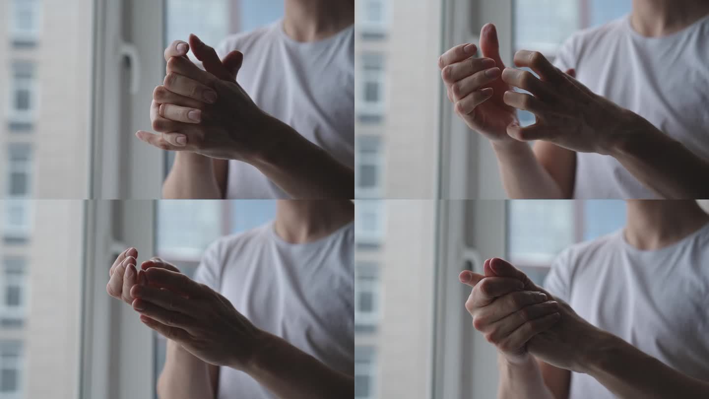 男性用手在干燥的皮肤上涂抹白色保湿霜的特写。在家治疗手干燥的特写。男性手部皮肤保湿霜乳液形式。