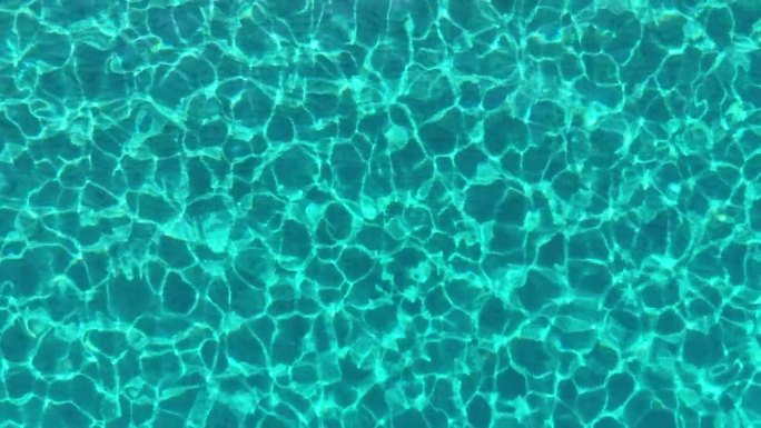 地中海的蓝绿色海水，底部有沙。空中俯瞰透明的蓝色海水与太阳光线的反射