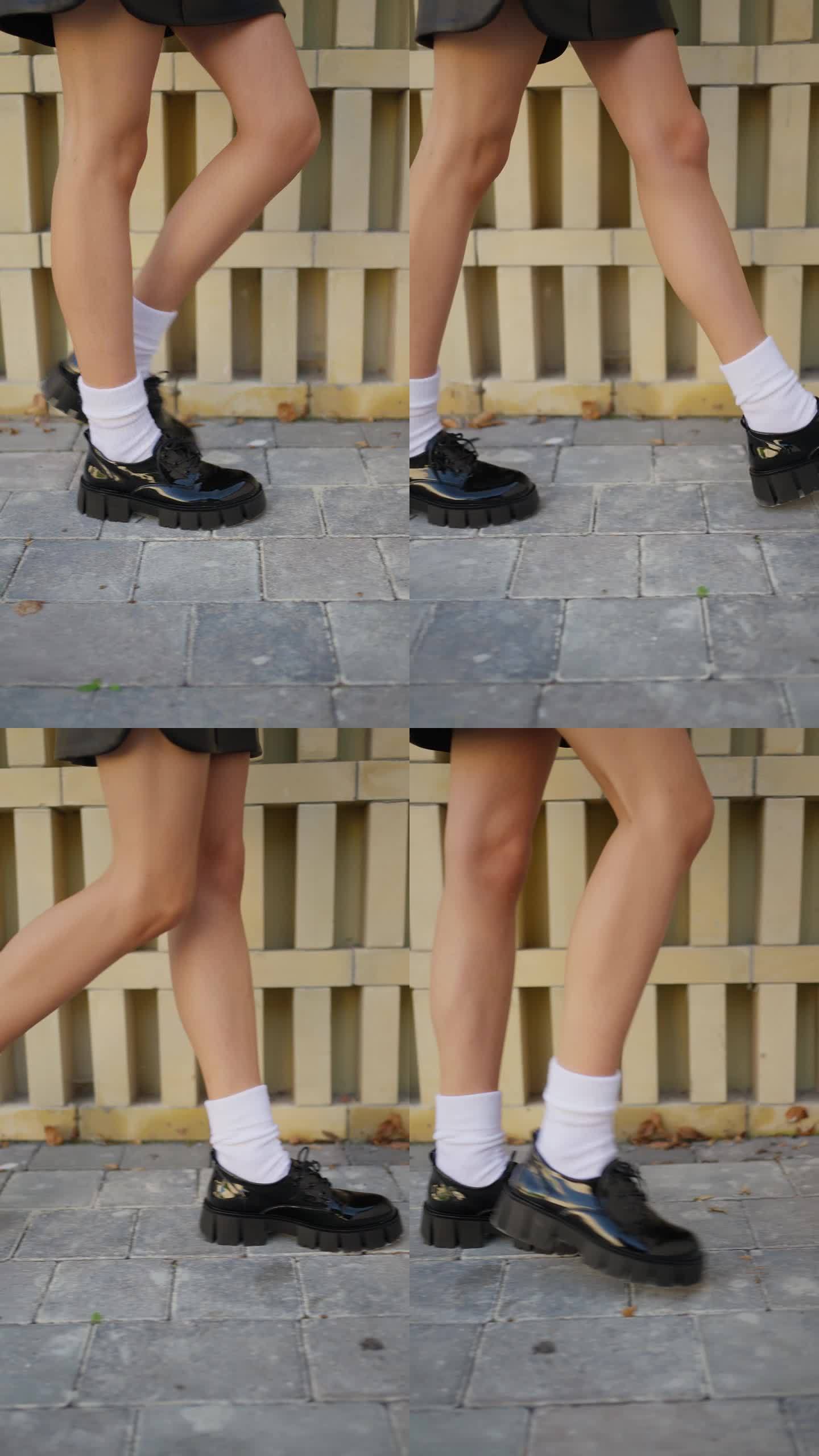 城市人行道上时髦的鞋袜。一个人的腿的特写，穿着时髦的黑鞋和白袜子，站在鹅卵石小路上。
