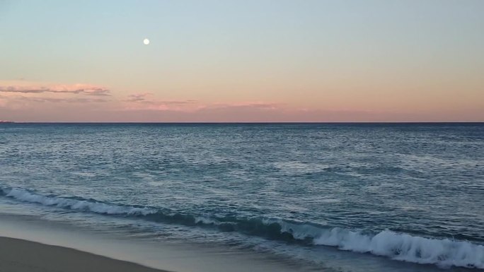 平静的大海，沙滩上的满月。晚上看海。