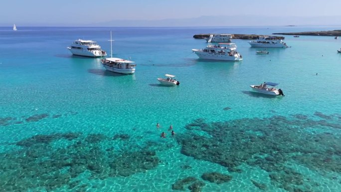 航拍的著名的蓝色泻湖在塞浦路斯岛。清澈碧绿的地中海海水和在塞浦路斯西海岸蓝色泻湖的游艇与游客