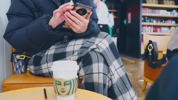 女人在星巴克喝咖啡看手机