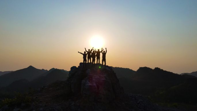 团队背影拥抱未来向往希望山顶呐喊挥手意境