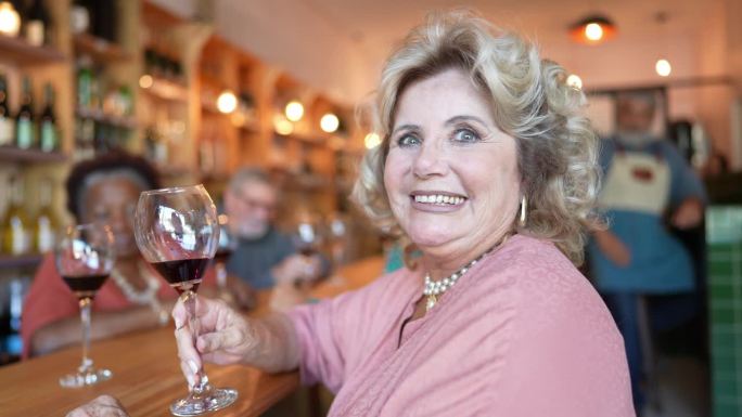 一个快乐的老年妇女和朋友在餐馆的画像