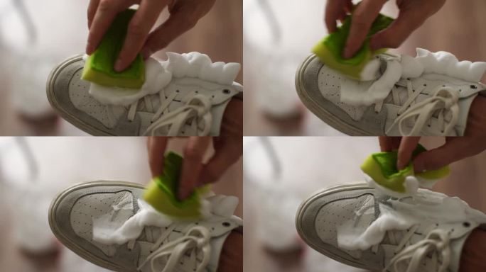 特写镜头，一个不知名的男人用海绵洗脏的白鞋子。男性擦拭球鞋上的污垢和灰尘。关爱鞋履的理念。