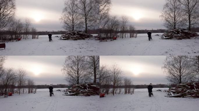 母亲推着婴儿车在下雪的乡下院子里靠近木桩