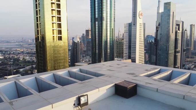 在阿联酋迪拜，一架无人机飞过有直升机停机坪的摩天大楼的屋顶。