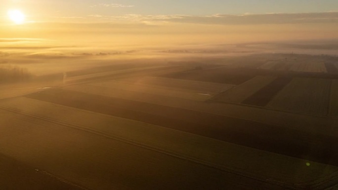 空中无人机拍摄雾和日出在宁静的农村农田