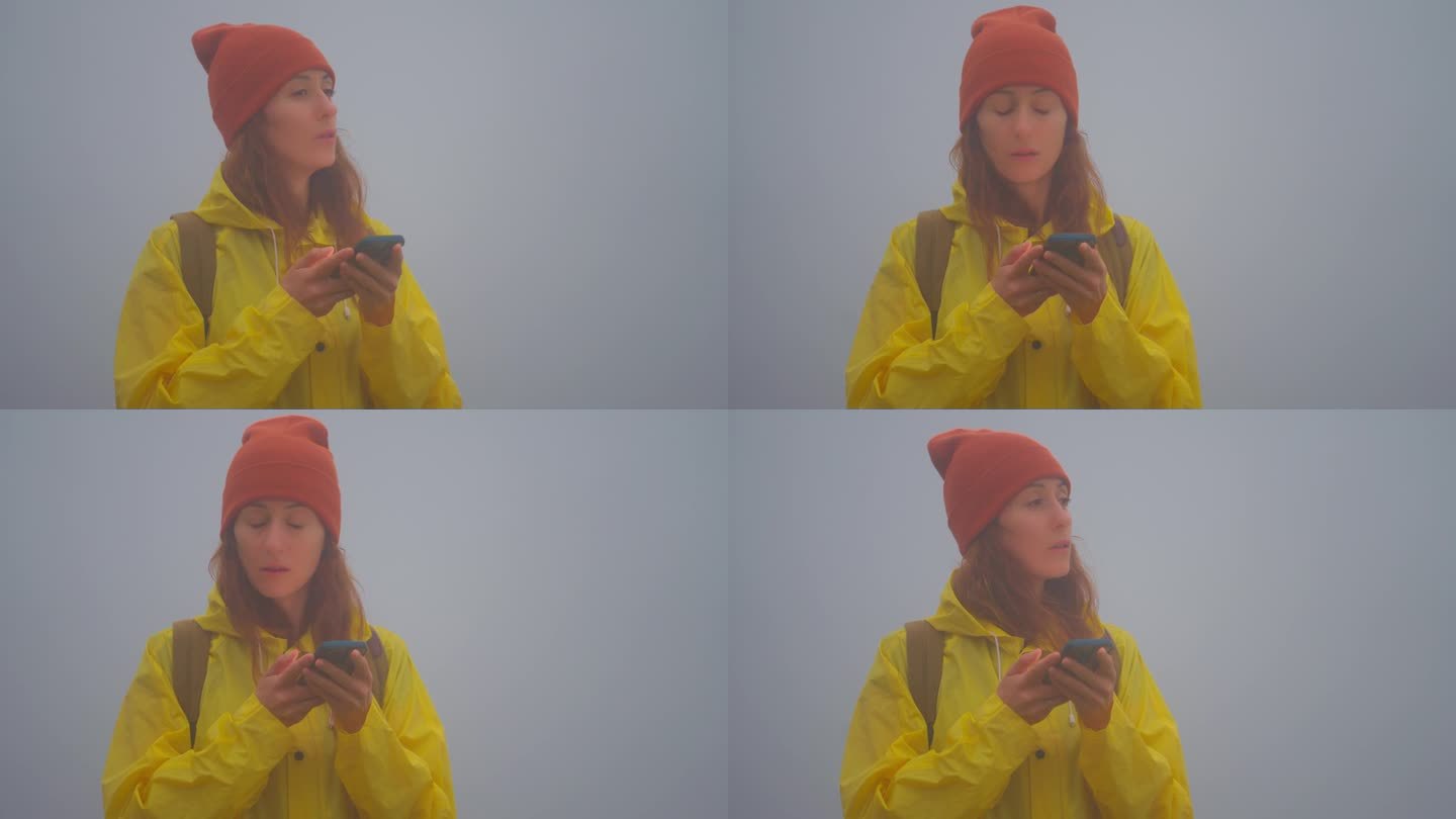 森林定向运动。背着背包的女游客在大雾中徒步旅行时迷路了，她用智能手机地图寻找正确的路