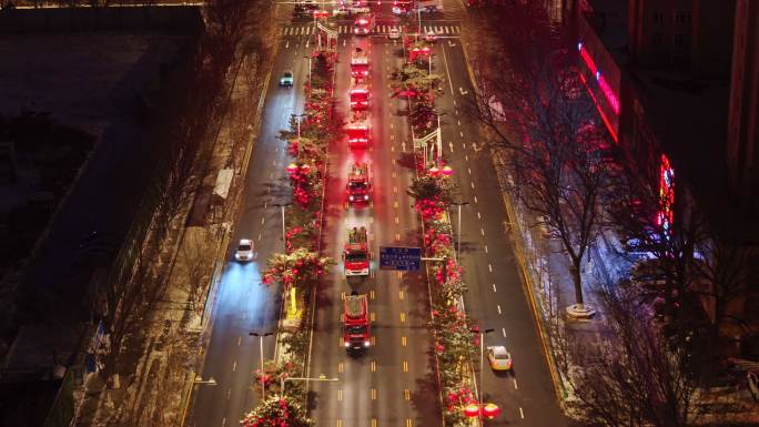 消防队消防车行驶在城市夜景街道上的航拍