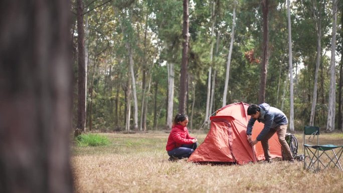一对旅行者在露营地搭帐篷