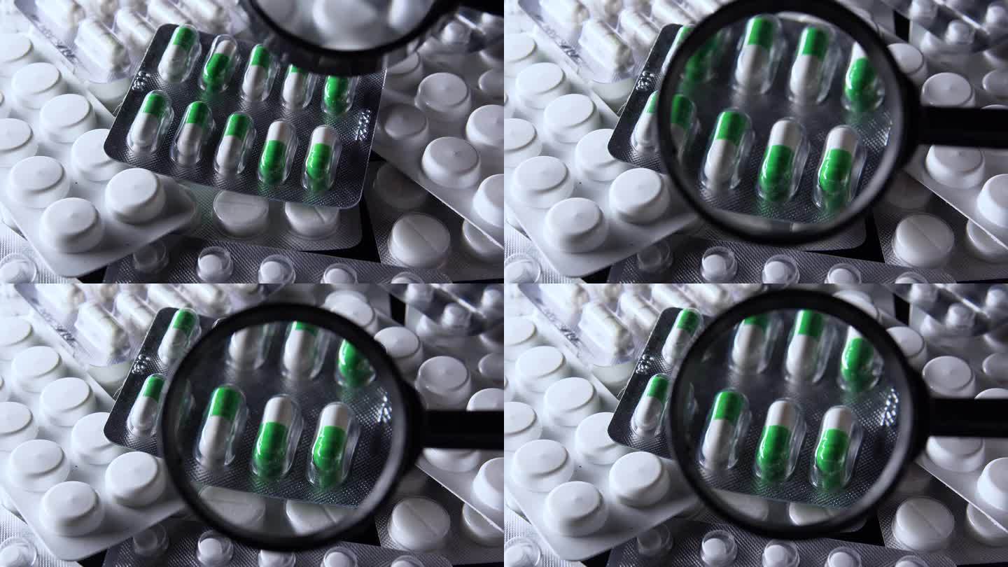 通过放大镜查看白色和绿色胶囊的水泡与其他药片，质量和有效期检查，检查片剂的原创性和符合标准