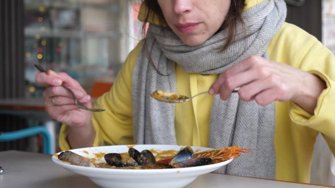 一名女子在马耳他的餐馆里喝海鲜鱼汤