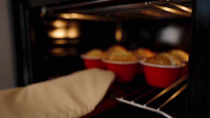 迷你烤箱，从里面取出刚烤好的纸杯蛋糕，慢镜头特写。