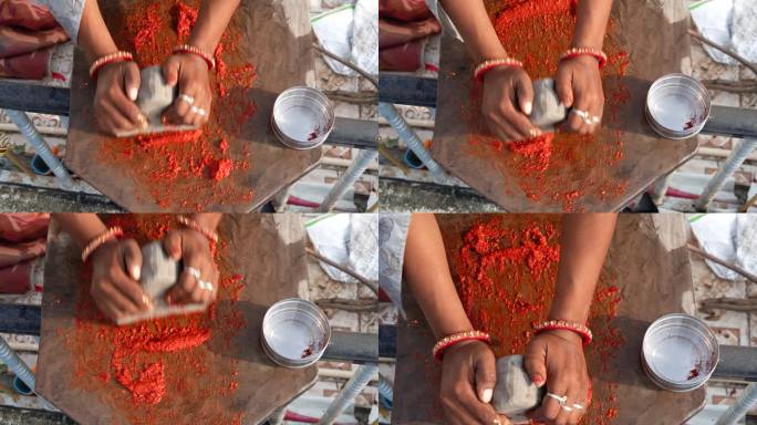 拉贾斯坦邦妇女的手正在用石制的研钵和杵把辣椒磨成传统的印度辣椒酱。