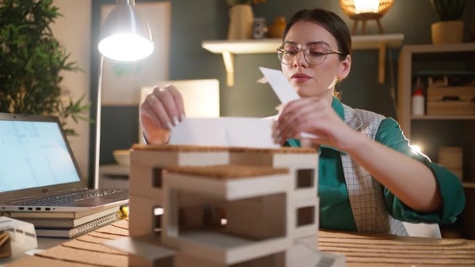 年轻的女建筑师用太阳能板制作现代生态住宅的建筑模型