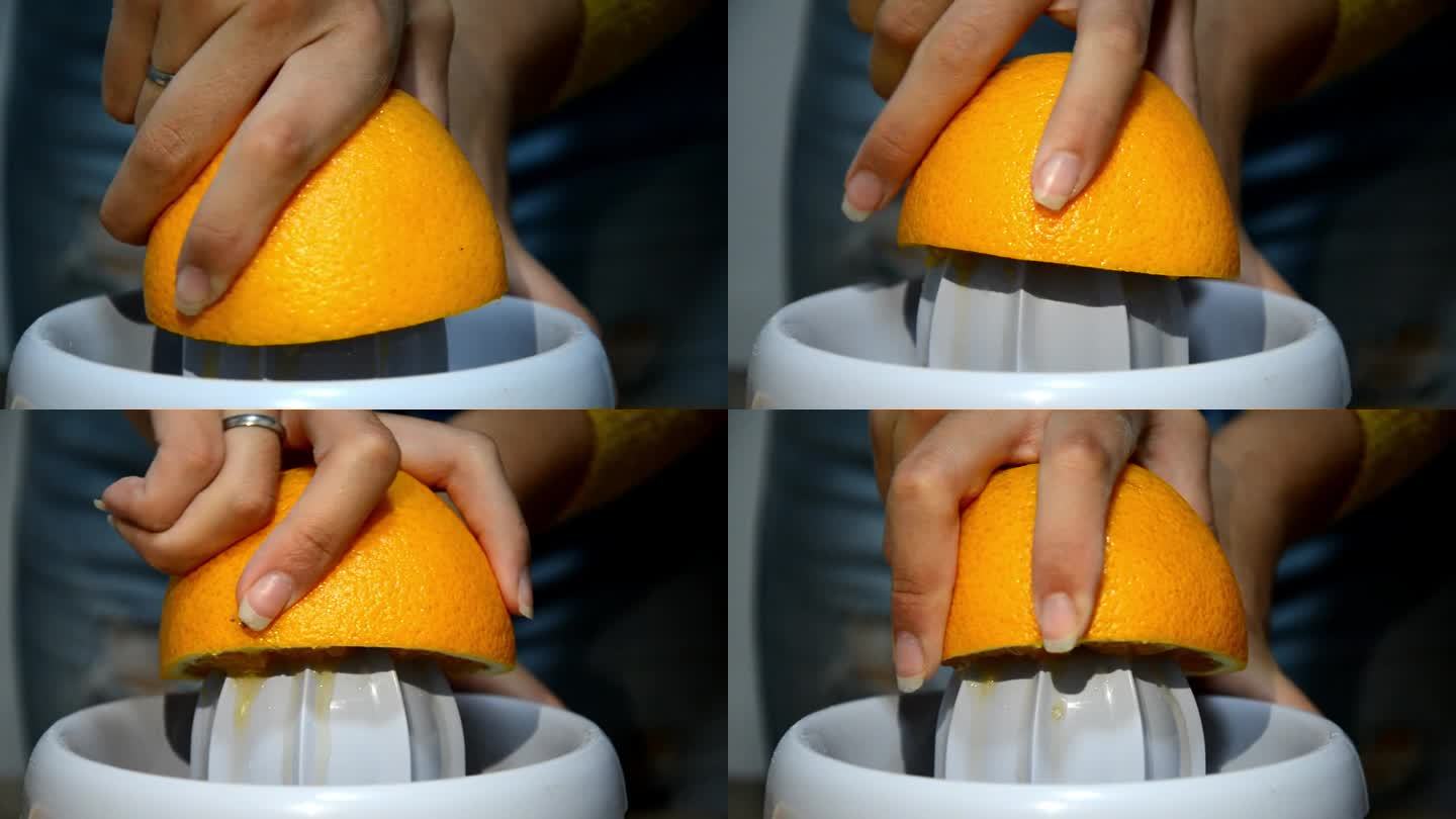 在榨汁机高清视频中，妇女双手榨汁新鲜橙子。以