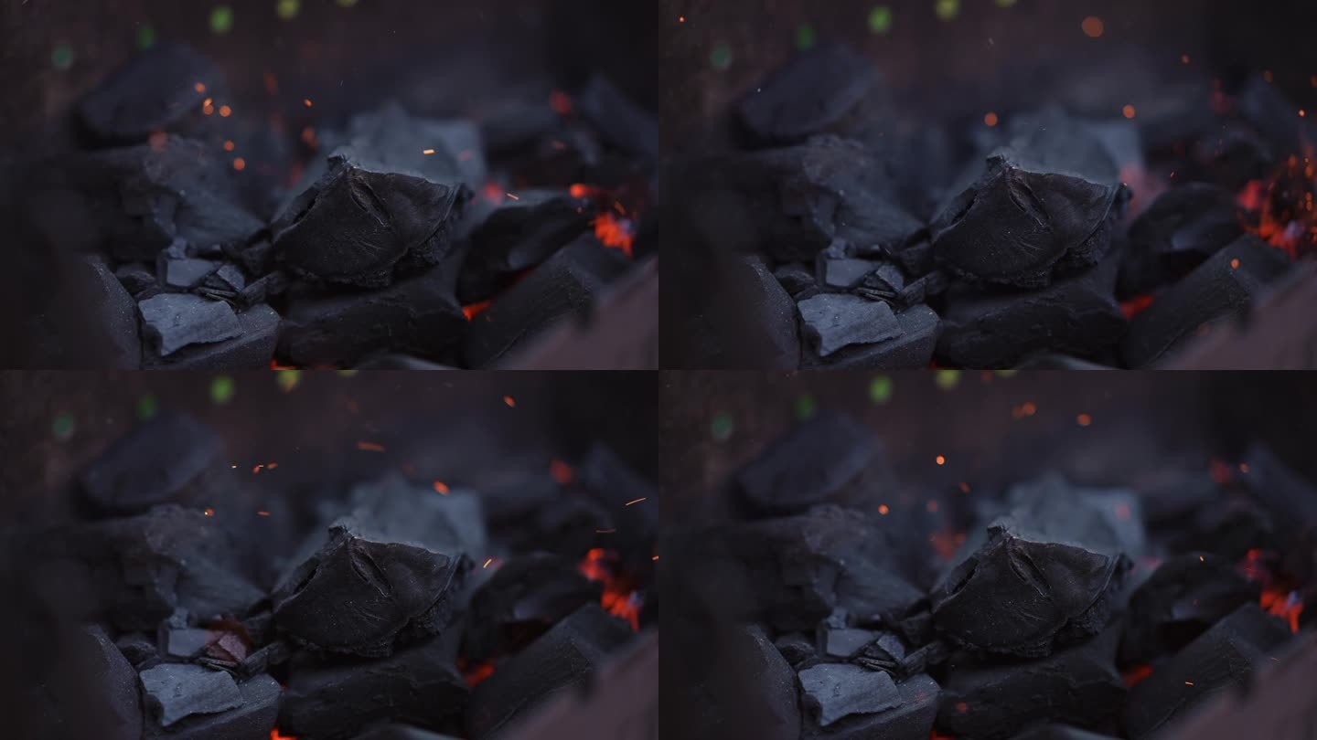 特写镜头。火中闷烧的煤。用塑料烧烤手扇扇火。