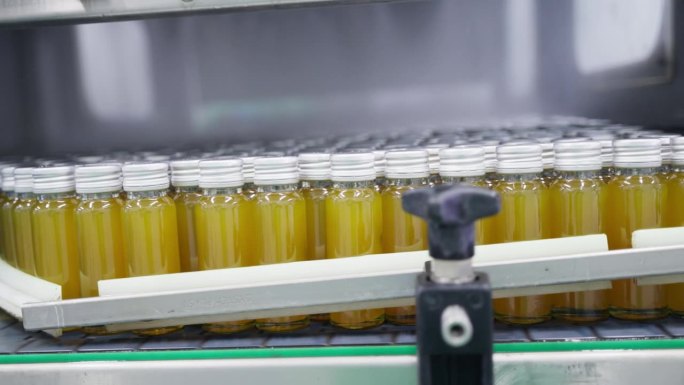 工厂内部的饮料，生产草药饮料产品的生产线，瓶装草药饮料站在机器冷却。健康饮料产业。