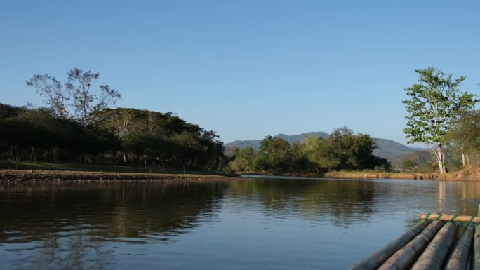 河中竹筏的特写，与山和自然景观