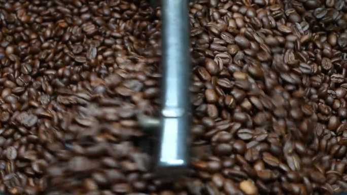 咖啡烘焙机在咖啡烘焙过程中的应用。混合咖啡豆。烘焙纺纱冷却器专业机器和新鲜的棕色咖啡豆运动在工厂的特