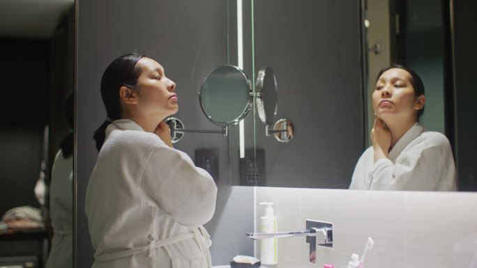 亚洲妇女在浴室用棉签洗脸