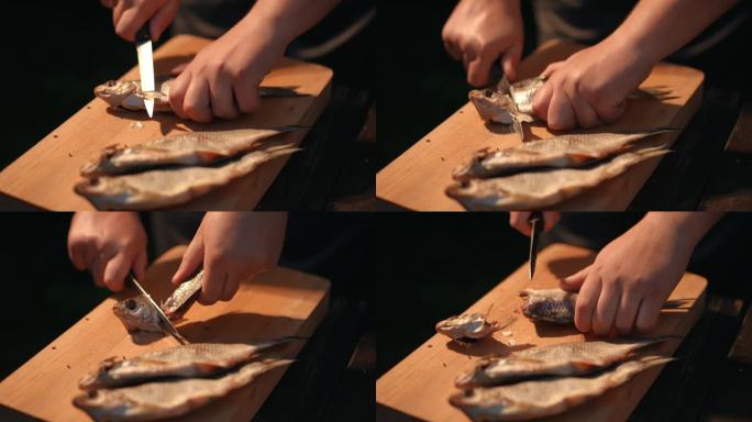 特写镜头。一名男子在木板上用刀切咸鱼干。