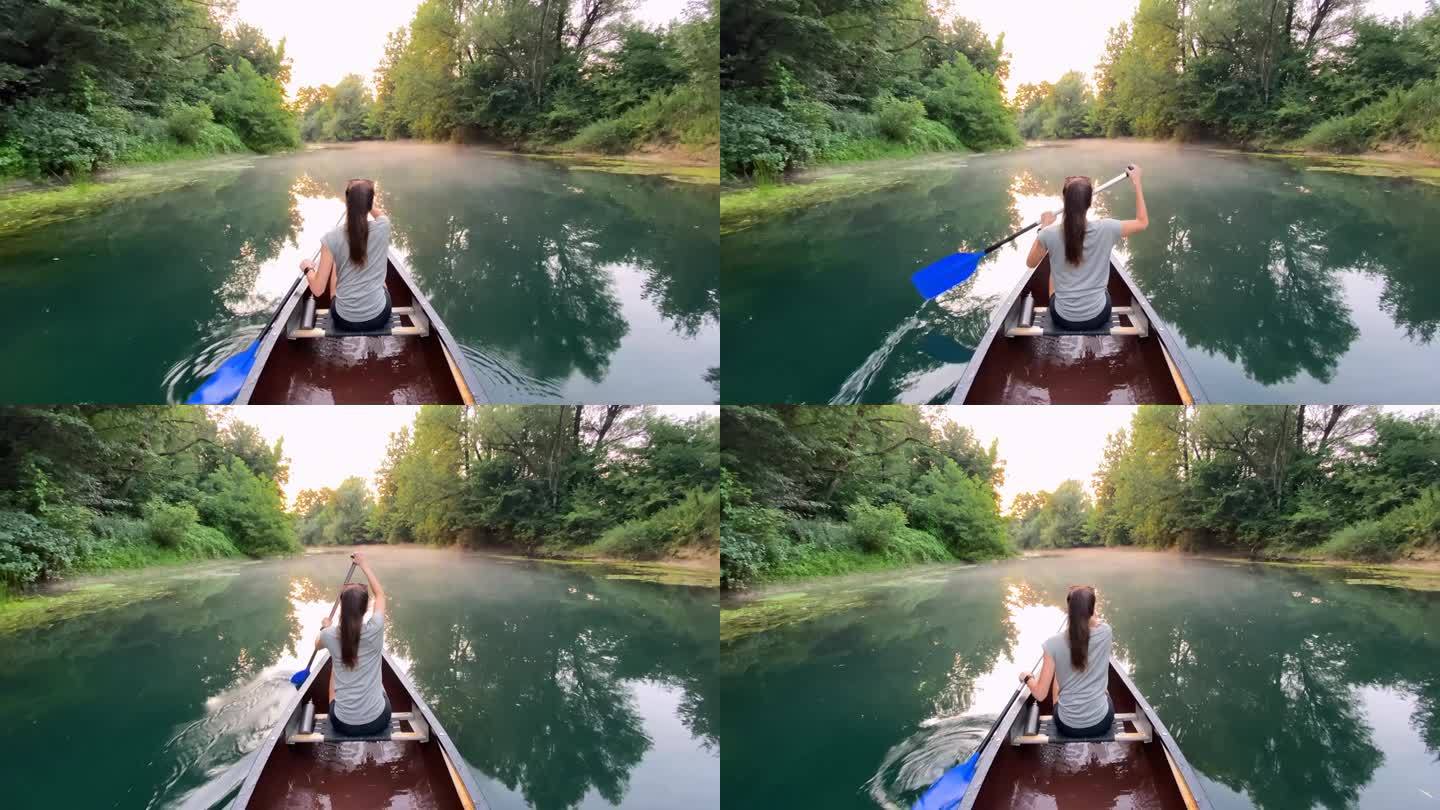 度假的女人，在一条迷人的河上划独木舟