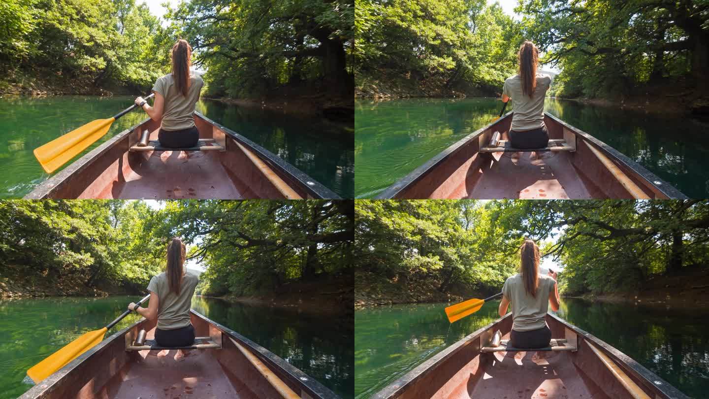 年轻女性享受假期，在河上划着独木舟