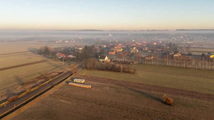 黎明时分，无人机拍摄到乡村农田和城镇上空的雾气