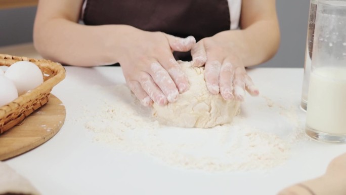 面包师的手在揉面团。烹饪艺术正在形成。制作完美糕点的原料。面面相觑的女人在揉面团
