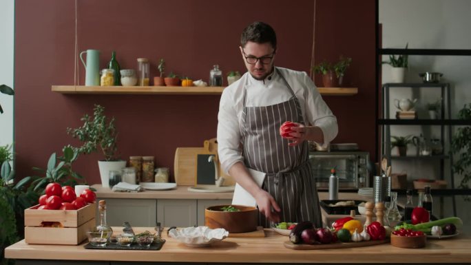 男厨师在拍摄烹饪节目时把西柚汁挤进沙拉里