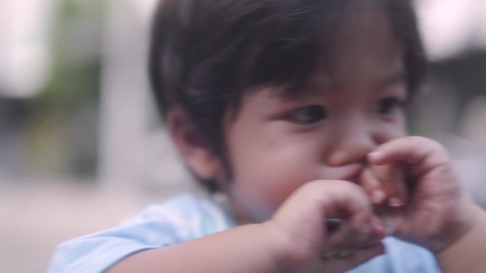 快乐的亚洲男孩在家吃果冻。吃得太多会导致蛀牙。
