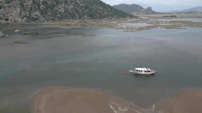 航拍大堰河上的一艘游船，旁边是İztuzu海龟海滩