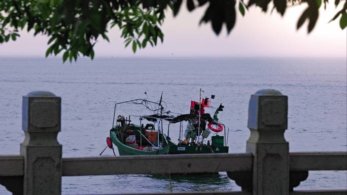 傍晚日落下海滨公园边安静的渔船