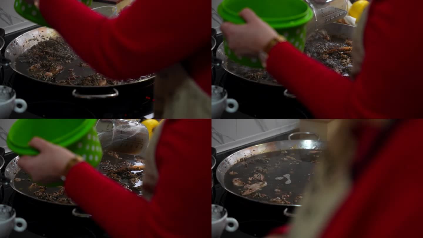 在厨房里，一名妇女正在往海鲜饭上浇水，用黑乌贼墨水煮米饭
