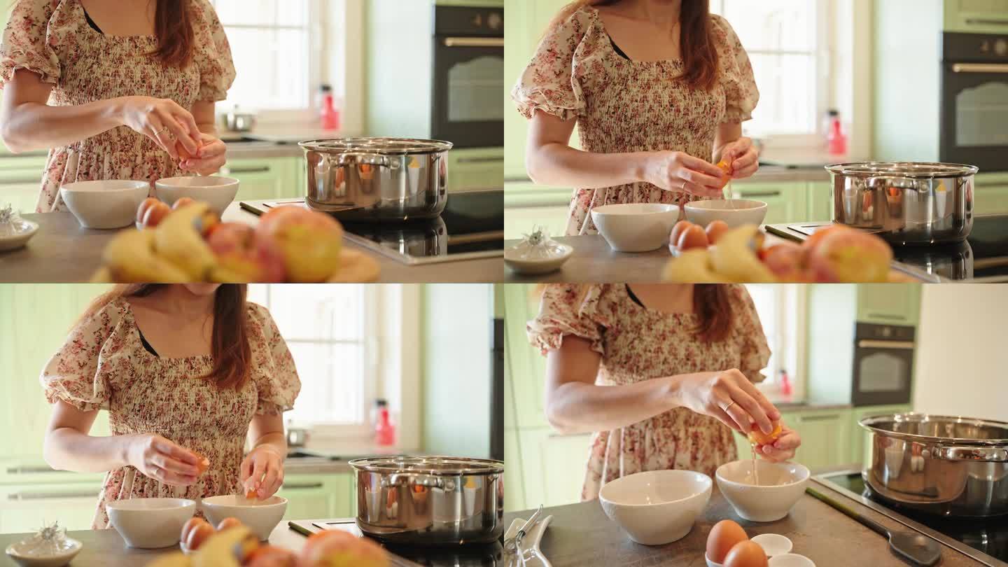 快乐的年轻女子在家里的厨房里把蛋清和蛋黄分进碗里