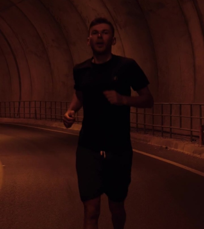 运行的概念。一个好动的男人在隧道里奔跑。垂直视频