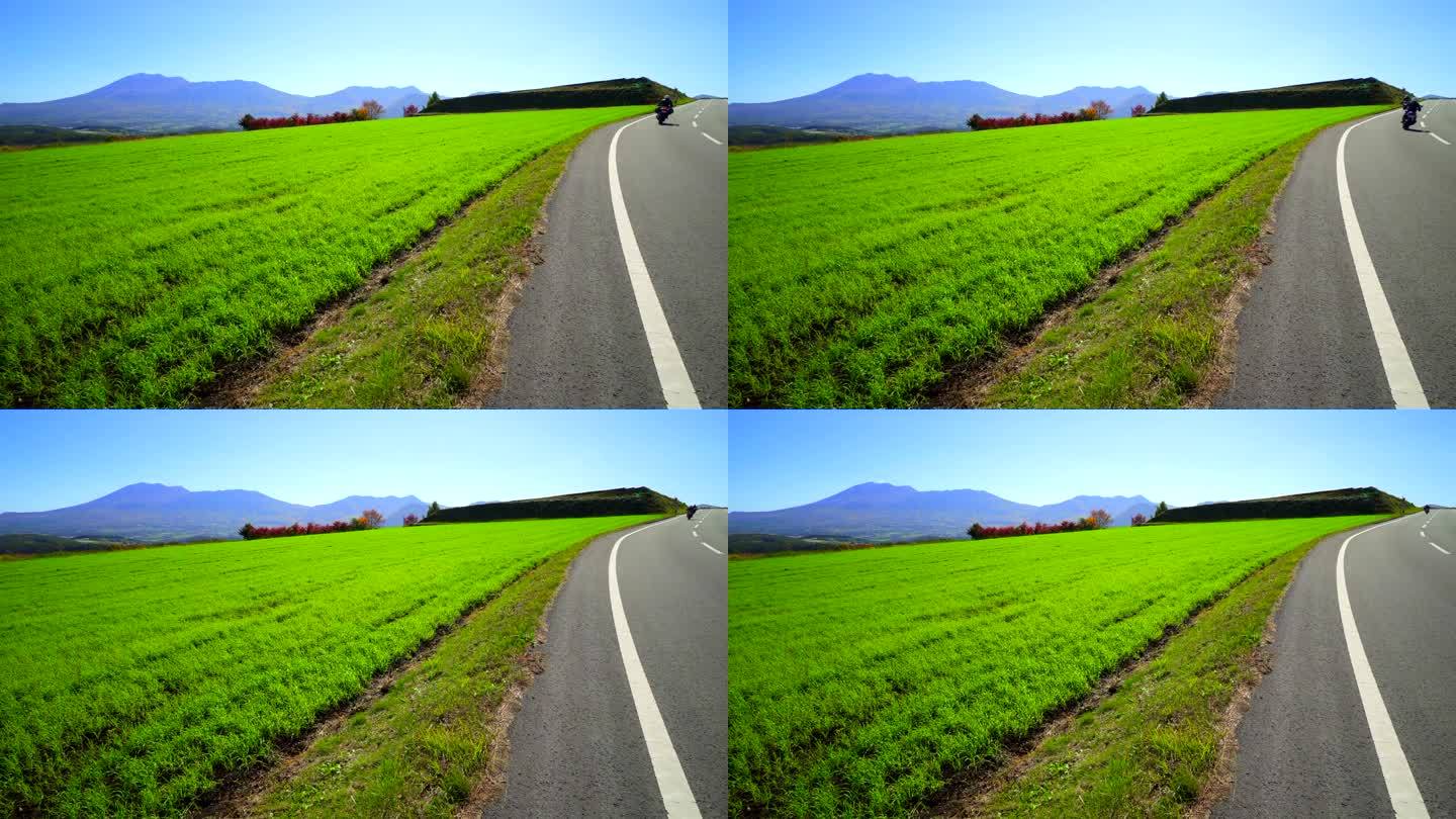 摩托车与浅间山穿过绿色草原:长野县津越村